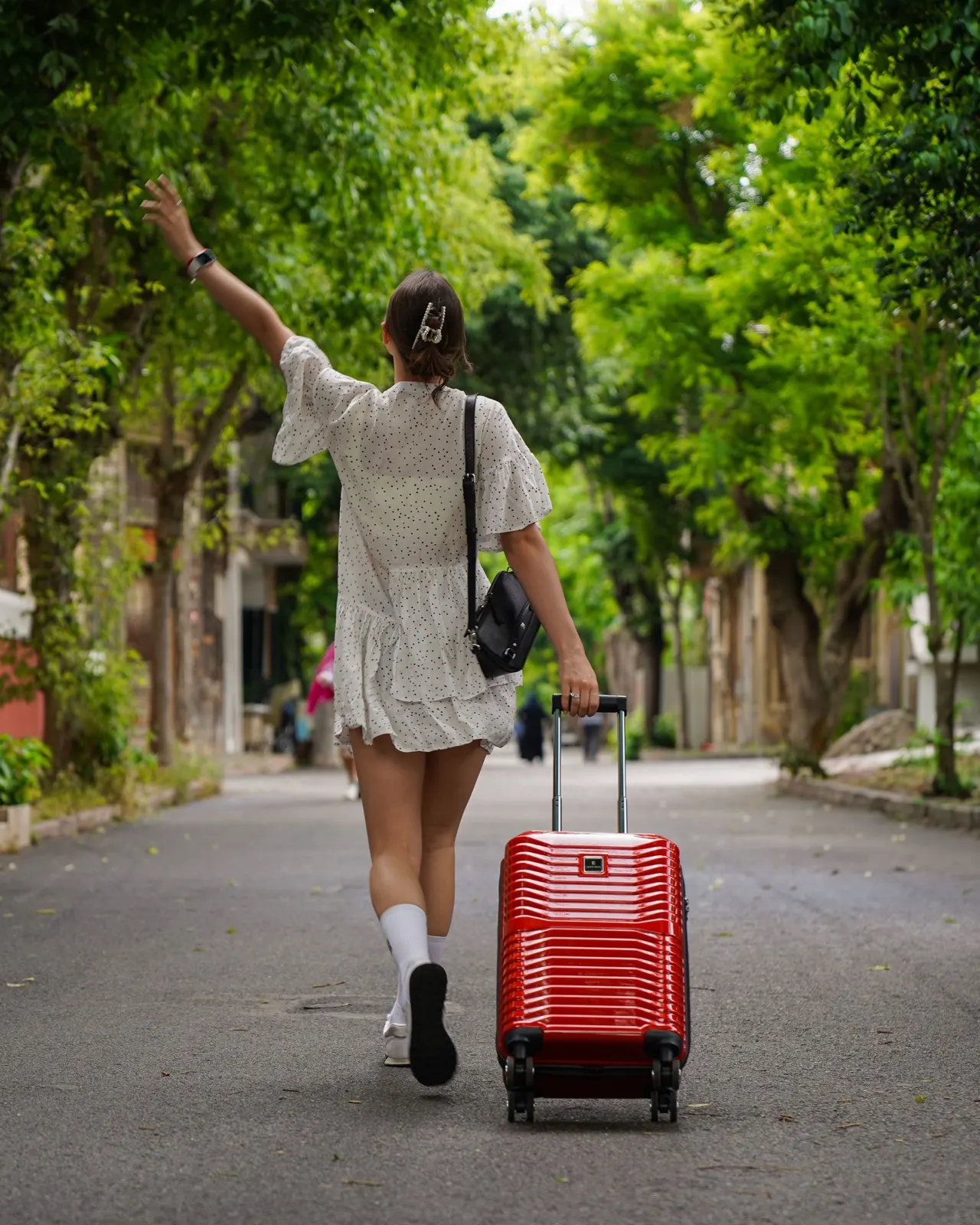 Traveller arriving with a red suitcase